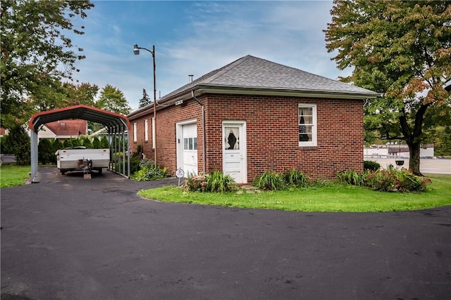 1820 N Hermitage Rd, Hermitage, PA 16148 - view of side of home with a detached carport, brick siding, and roof with shingles