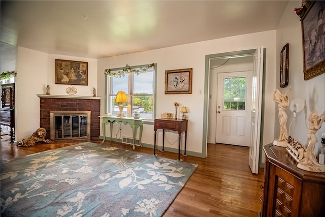 sitting room with a healthy amount of sunlight, a fireplace, and hardwood / wood-style floors