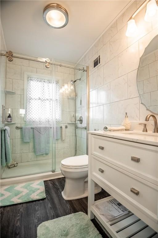 1820 N Hermitage Rd, Hermitage, PA 16148 - full bath featuring visible vents, toilet, vanity, tile walls, and a stall shower