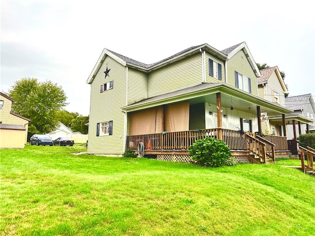 rear view of property featuring covered porch and a yard