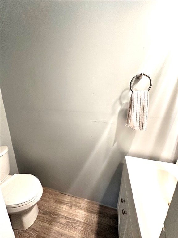 bathroom with hardwood / wood-style floors, vanity, and toilet