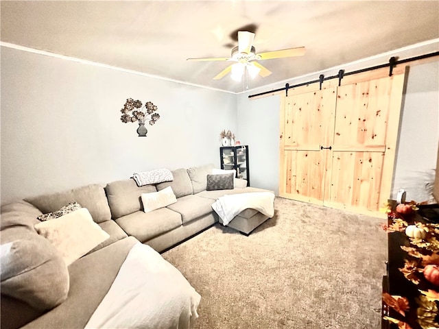 carpeted living room featuring ceiling fan, ornamental molding, and a barn door