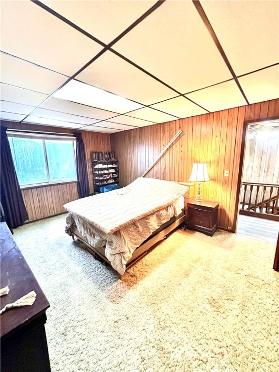 carpeted bedroom featuring pool table, a drop ceiling, and wooden walls