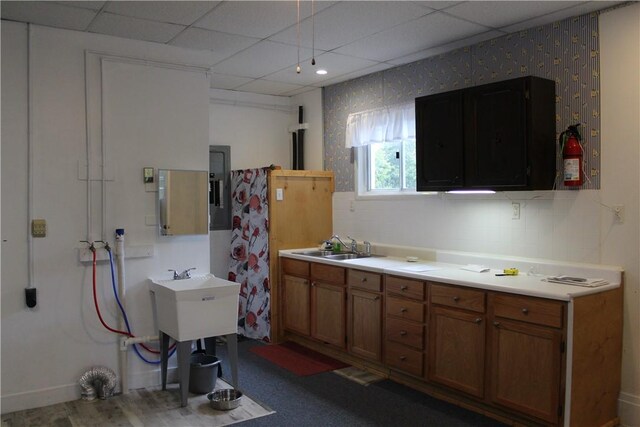 kitchen featuring sink, electric panel, and a paneled ceiling