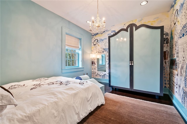 bedroom with a notable chandelier and dark hardwood / wood-style floors