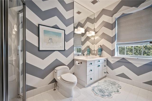 bathroom featuring tile patterned flooring, walk in shower, vanity, and toilet