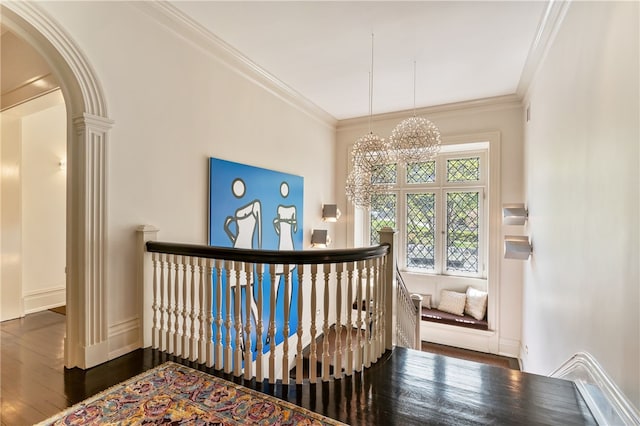 corridor featuring crown molding, dark hardwood / wood-style floors, and a notable chandelier