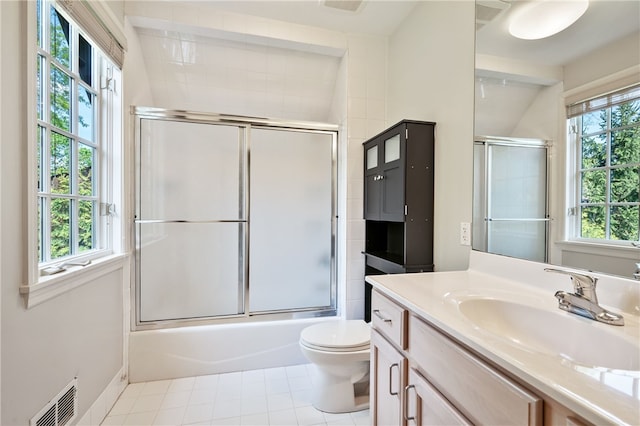 full bathroom featuring tile patterned floors, bath / shower combo with glass door, vanity, and toilet