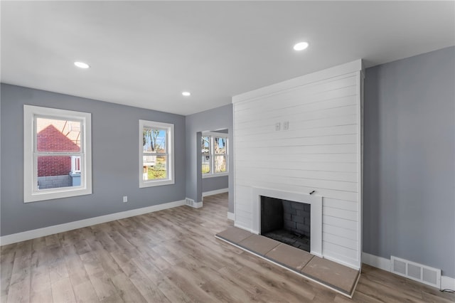 unfurnished living room featuring light hardwood / wood-style floors and a fireplace