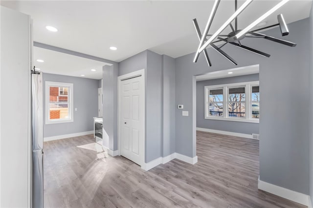 interior space featuring a chandelier, light hardwood / wood-style floors, and a healthy amount of sunlight