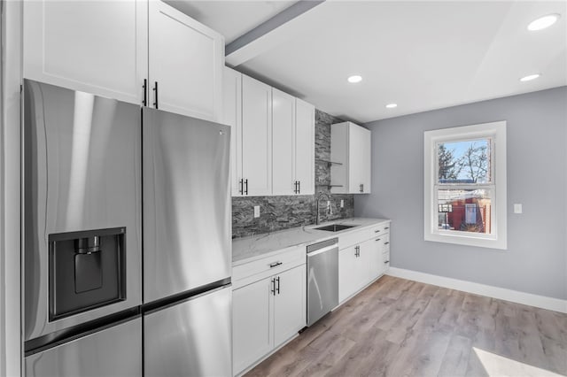 kitchen featuring white cabinetry, appliances with stainless steel finishes, sink, and light wood-type flooring