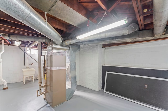 basement featuring heating unit and sink