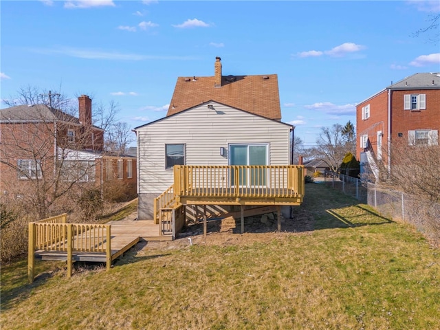 rear view of house featuring a deck and a yard