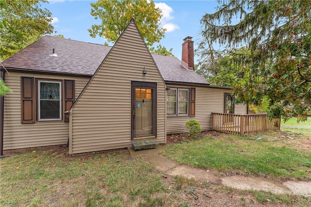 rear view of property featuring a lawn