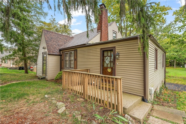 rear view of property featuring a wooden deck and a yard