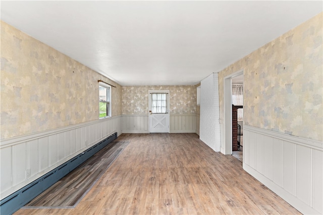 spare room with a baseboard heating unit and wood-type flooring