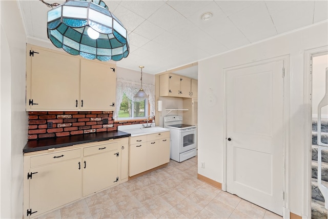 kitchen with hanging light fixtures, sink, cream cabinets, backsplash, and electric stove