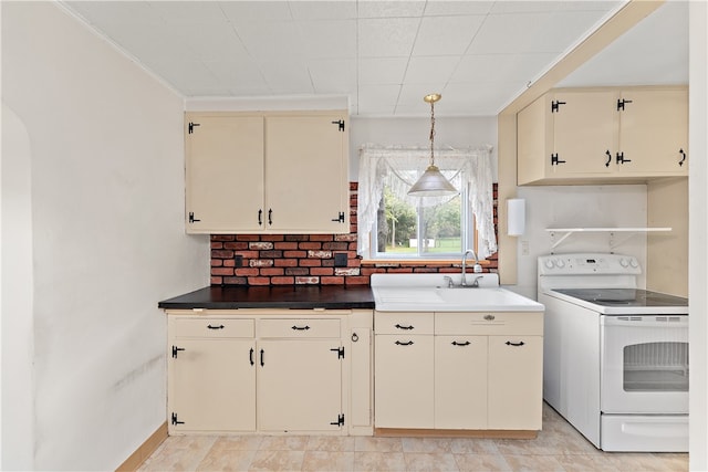 kitchen featuring pendant lighting, tasteful backsplash, sink, cream cabinets, and white electric range