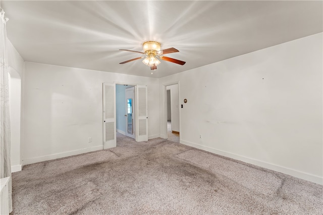 empty room featuring ceiling fan and light colored carpet