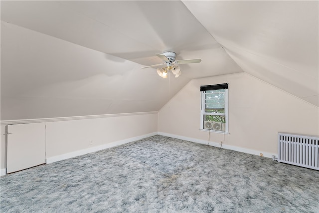 additional living space with carpet flooring, vaulted ceiling, ceiling fan, and radiator