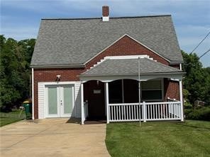 view of front of property with french doors and a front lawn