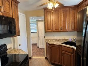 kitchen featuring ceiling fan, vaulted ceiling, sink, and black appliances