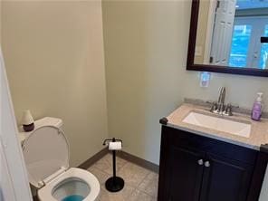 bathroom featuring tile patterned flooring, vanity, and toilet