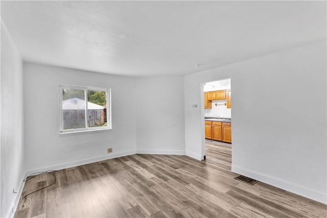 empty room featuring sink and hardwood / wood-style flooring