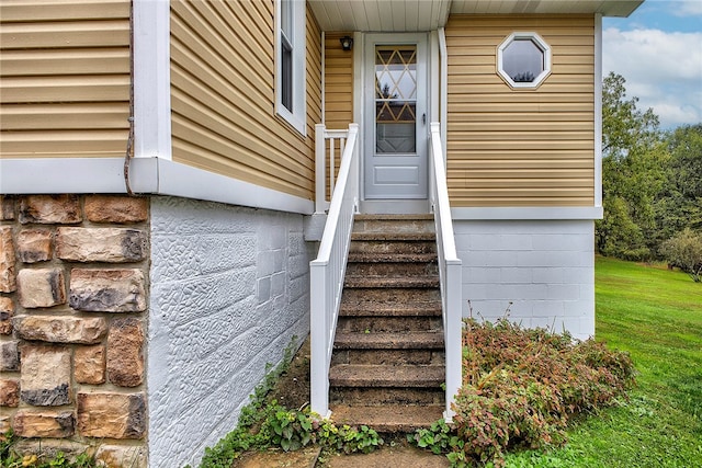 view of exterior entry featuring a yard