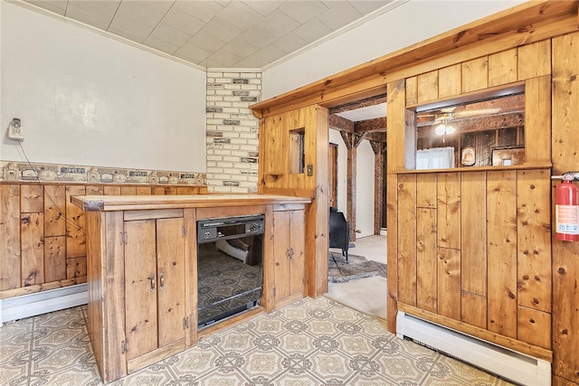 kitchen with dishwasher, wooden walls, and a baseboard radiator