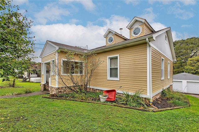 exterior space featuring an outbuilding, a yard, and a garage