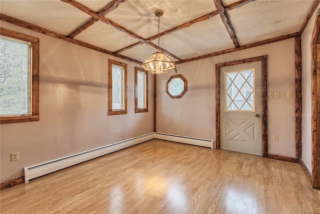 foyer entrance with a notable chandelier, a textured ceiling, light hardwood / wood-style flooring, and plenty of natural light