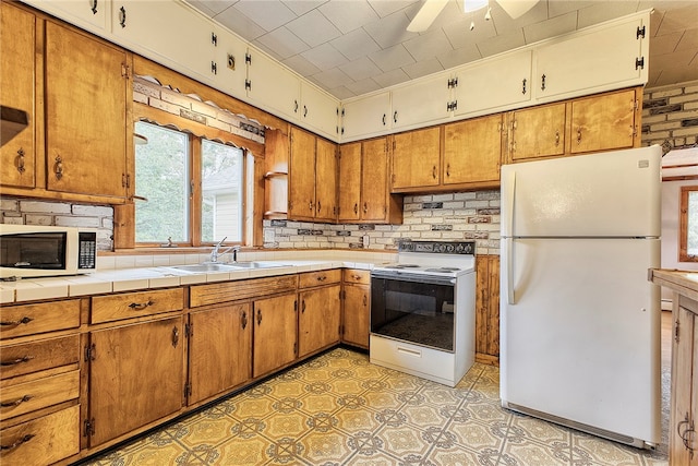 kitchen featuring tasteful backsplash, white appliances, ceiling fan, tile counters, and sink