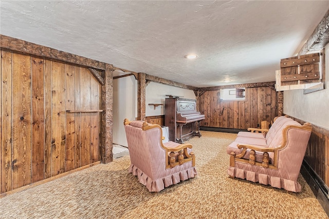 living room with wooden walls, a textured ceiling, and carpet flooring