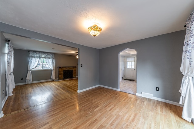 unfurnished living room featuring a fireplace and light hardwood / wood-style floors