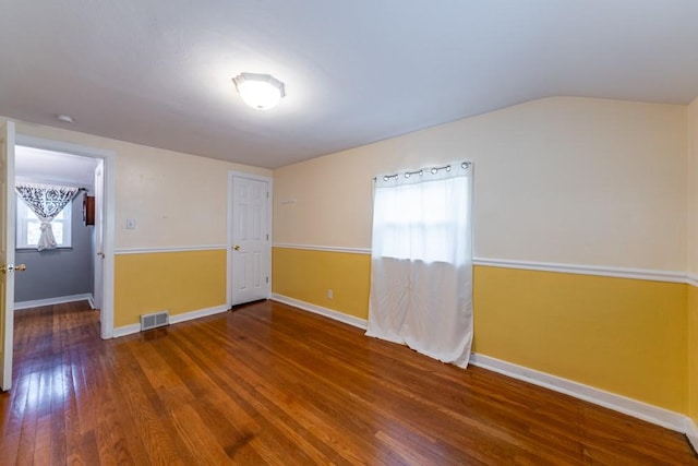 spare room with hardwood / wood-style floors, baseboards, and visible vents