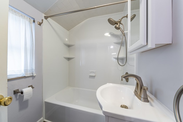 bathroom featuring lofted ceiling, bathing tub / shower combination, and vanity