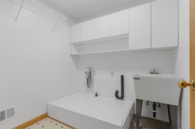 laundry room featuring sink, washer hookup, and cabinets