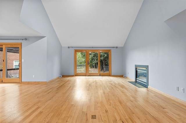 unfurnished living room with lofted ceiling and light wood-type flooring