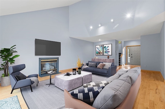 living room featuring light wood-type flooring and vaulted ceiling