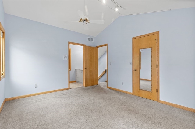 carpeted empty room featuring ceiling fan, track lighting, and vaulted ceiling