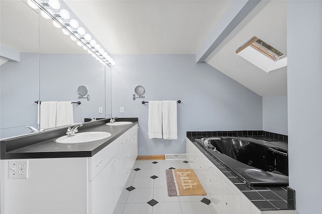 bathroom with a bath, lofted ceiling with skylight, and vanity