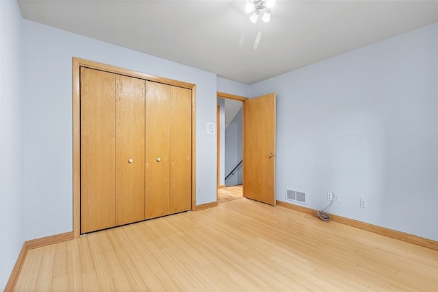 unfurnished bedroom with a closet and light hardwood / wood-style flooring