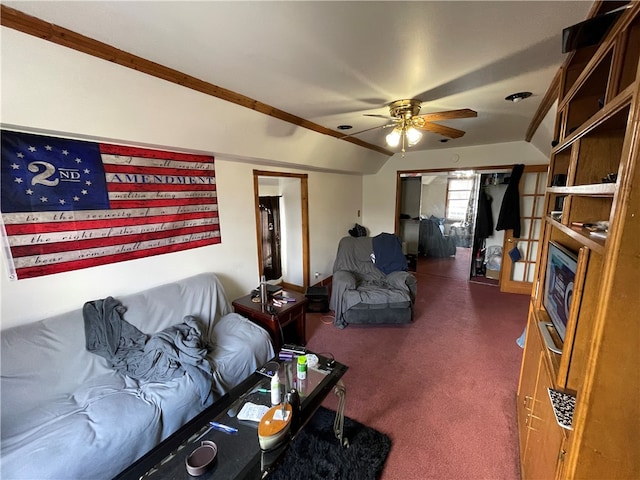 carpeted living room with ceiling fan and vaulted ceiling