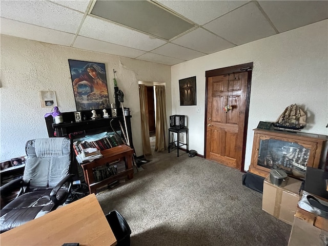 carpeted home office with a paneled ceiling