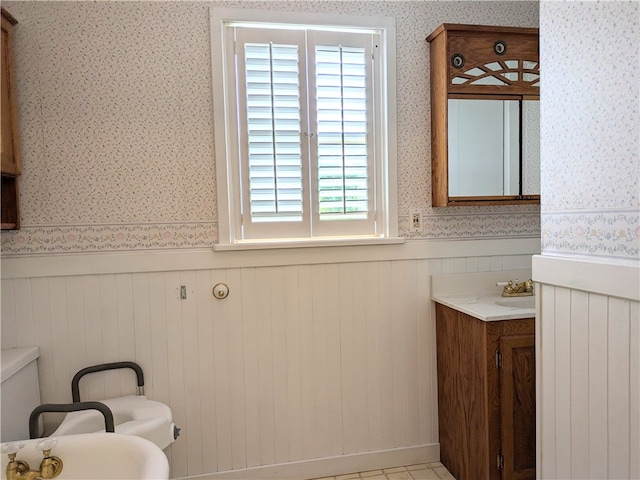 bathroom featuring vanity, toilet, and wood walls