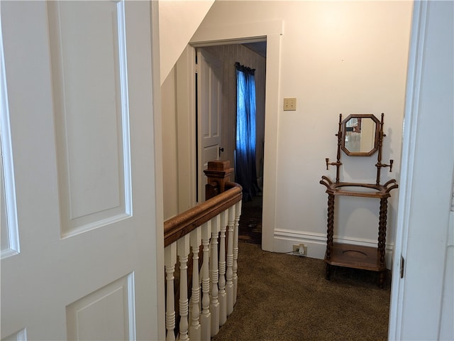 hallway featuring dark carpet