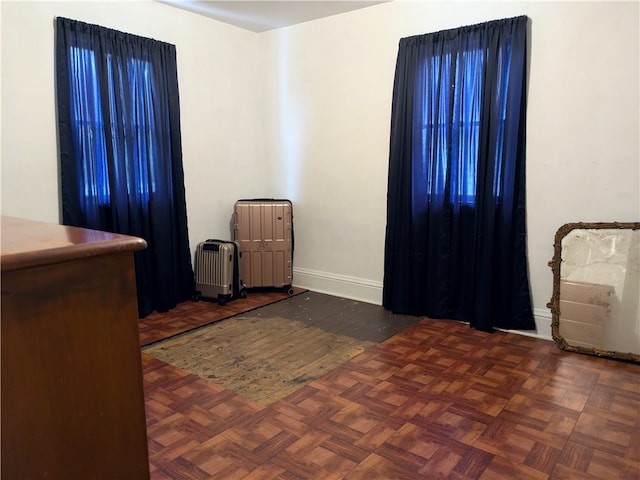 unfurnished bedroom with dark parquet flooring