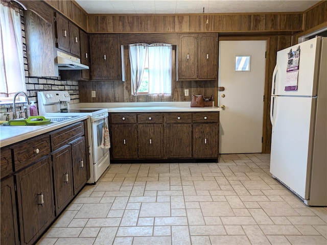 kitchen with tasteful backsplash, sink, dark brown cabinets, and white appliances