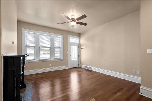 unfurnished living room with dark hardwood / wood-style floors and ceiling fan